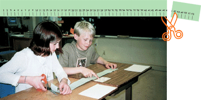 Students cutting the required number of centimeters from their meter strip